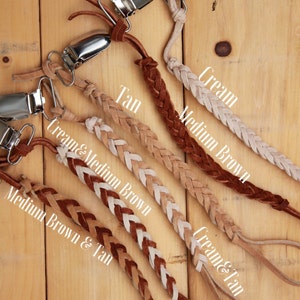 May include: Five braided leather straps with metal clips. The straps are in different color combinations: cream, medium brown, tan, cream and medium brown, and cream and tan.