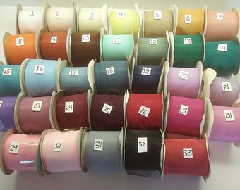 May include: Thirty-three spools of ribbon in various colors, including orange, green, pink, blue, and red. The spools are numbered 1 through 33.