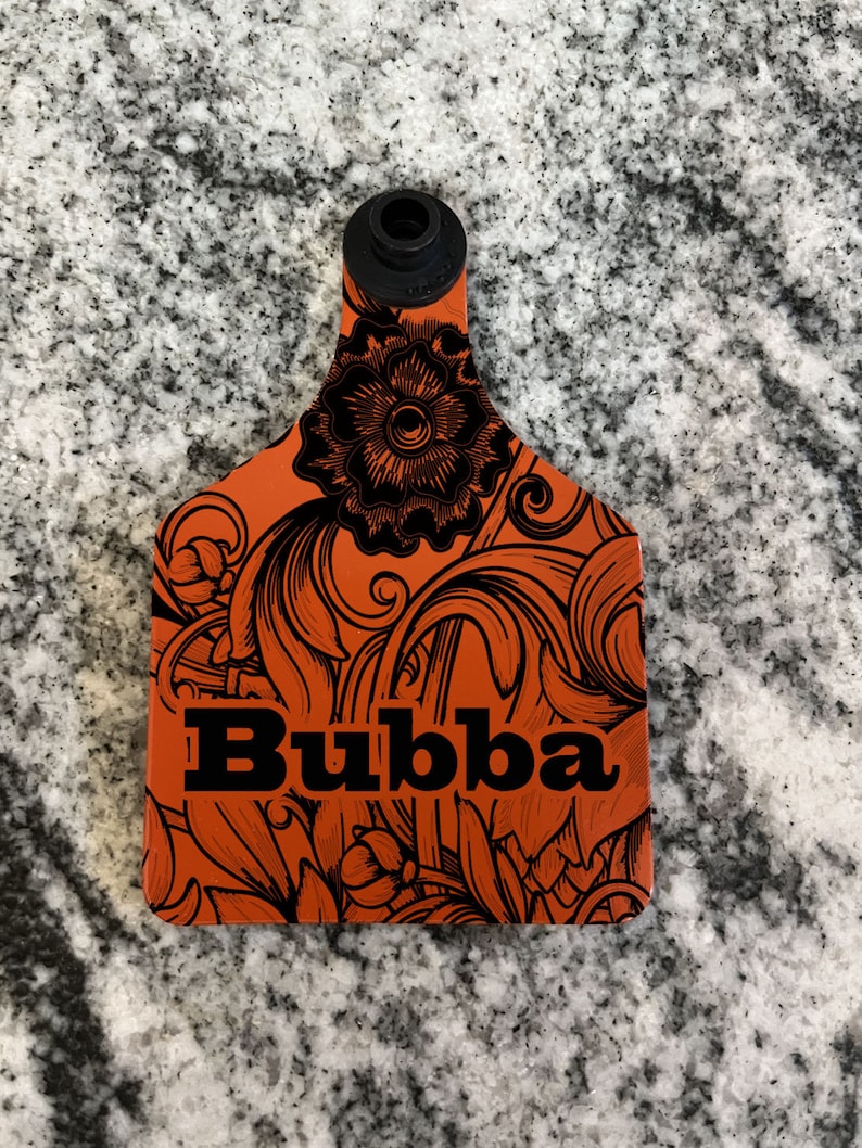 May include: Orange plastic tag with a black floral design and the word "Bubba" in black lettering.