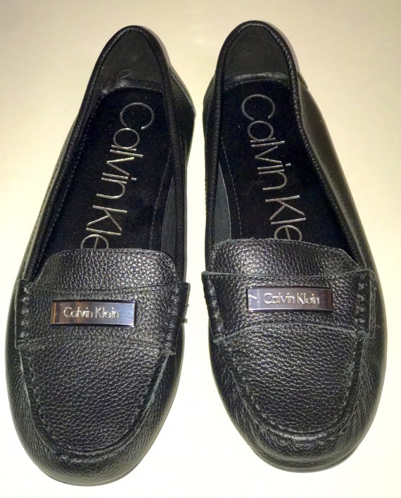 Brand New Women's 6.5 Black Pebbled Textured Leather Calvin Klein Leta Silver Metal Plaque Comfortable Slip on Loafer Driving Moccasins