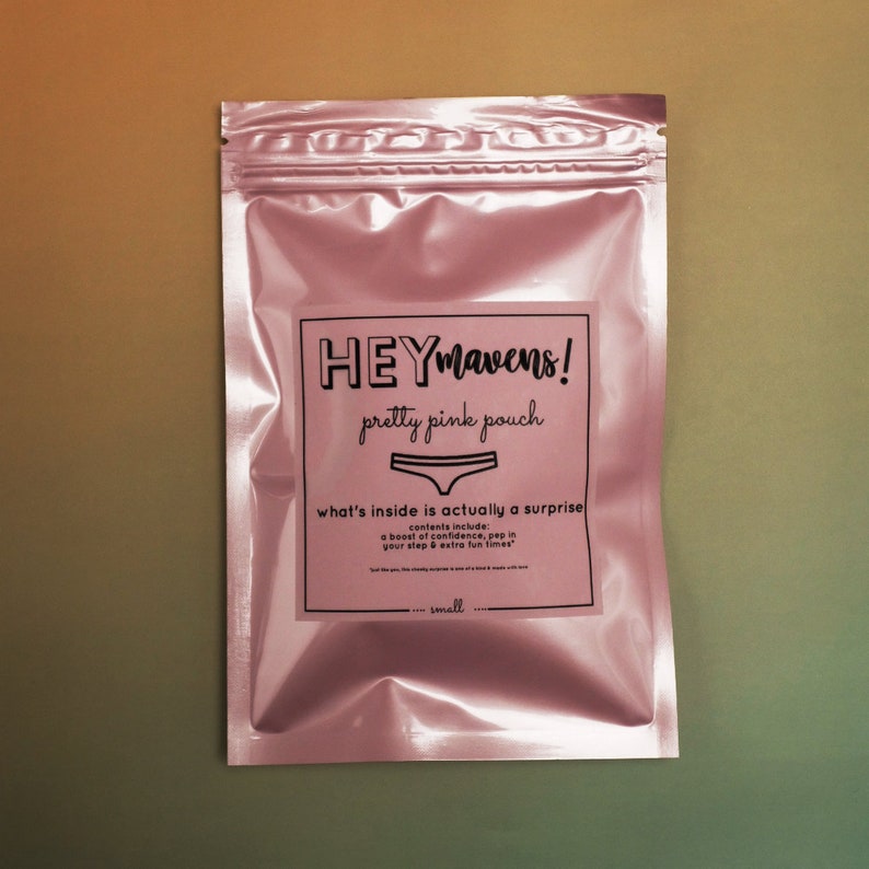 May include: A pink pouch with a label that reads "HEYmavens! pretty pink pouch what's inside is actually a surprise contents include: a boost of confidence, pep in your step & extra fun times small"