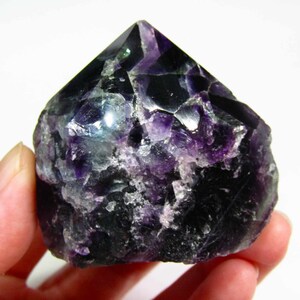 May include: A dark purple and green fluorite crystal point with a rough, natural surface. The crystal is about 2 inches tall and has a pointed tip.