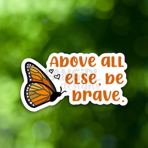 May include: A white sticker with an orange and black butterfly and the text "Above all else, be brave."