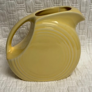 Fiestaware Small Yellow pitcher Fiesta Ware retired light yellow post 86 juice Disk Pitcher (glaze flaw inside)