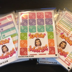 May include: Several sticker sheets in clear packaging. One sheet features colorful "Pay Day" stickers. Another sheet has "What's for dinner?" stickers. The "Oopsie" logo and "Lexington Flair" text are visible.