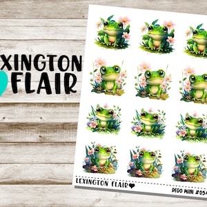 May include: A sheet of 12 frog stickers with a white background. Each sticker features a green frog with pink flowers and green leaves. The stickers are labeled "Deco Mini #054".