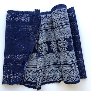 May include: A blue fabric with a white geometric pattern. The fabric is folded and rolled up.