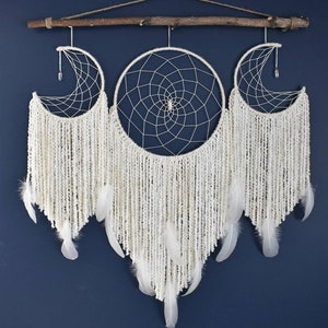 May include: White dream catcher with three hoops, two crescent moon shaped and one round, with white yarn and feathers hanging from the bottom.