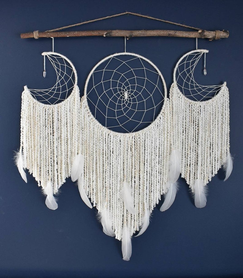 May include: White dream catcher with three hoops, two crescent moon shaped and one round, with white yarn and feathers hanging from the bottom.