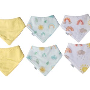 May include: Six baby bibs, two are solid yellow and four have a pattern of rainbows, suns, and leaves on a light blue background.