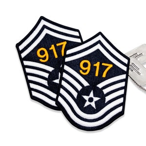 May include: Two navy blue and white embroidered patches with the number "917" in yellow. Each patch features a white star and a series of white stripes. The patches are likely military insignia.