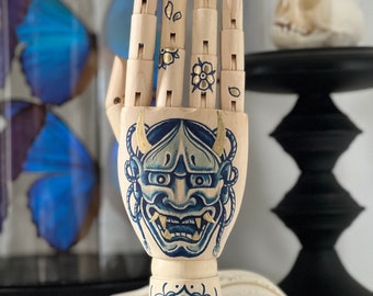 Wooden hand with a hanya mask and flower tattoo design