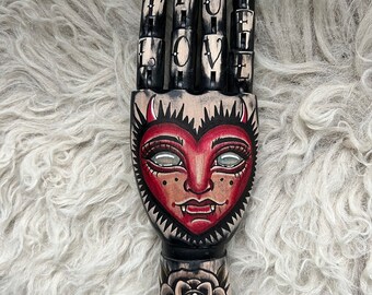 Schwarze Holzhand mit Herz- und Rosen-Tattoo-Design