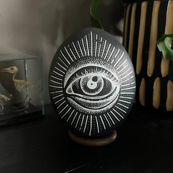 Oeuf d'autruche peint en noir avec un dessin original d'un œil qui voit tout