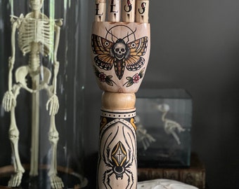Holzarm und -hand mit Totenkopf-Motten-, Spinnen- und Skorpion-Tattoo-Design