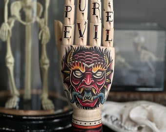 Hand aus Holz mit einem Dämon und Flammen Tattoo Design