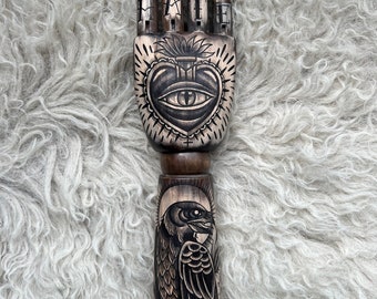 Bras et main en bois avec un tatouage de coeur sacré, de corbeau et de rose