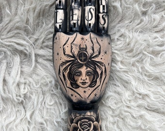 Schwarze Holzhand mit Spinnen- und Rosen-Tattoo-Design