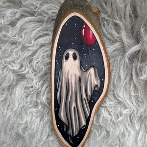 Tranche de bois avec un dessin original d'un fantôme tenant un ballon