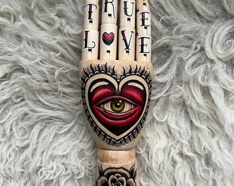 Hand aus Holz mit einem Herz und Rose Tattoo-Design