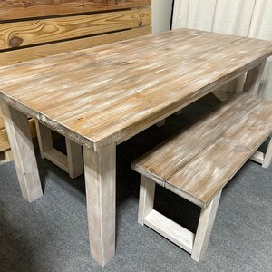 K&ouml;nnte beinhalten: Ein wei&szlig; gestrichener Holz-Esstisch mit einer passenden Bank. Der Tisch hat eine rechteckige Tischplatte und vier Beine. Die Bank hat eine rechteckige Tischplatte und zwei Beine an jedem Ende.