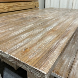 K&ouml;nnte beinhalten: Ein wei&szlig; get&uuml;nchter Holztisch mit einer abgenutzten Oberfl&auml;che. Der Tisch hat eine rechteckige Tischplatte und ein schlichtes Design.