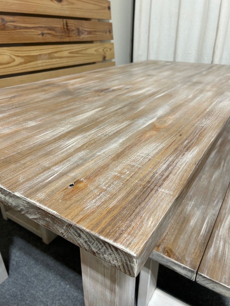 K&ouml;nnte beinhalten: Ein wei&szlig; get&uuml;nchter Holztisch mit einer abgenutzten Oberfl&auml;che. Der Tisch hat eine rechteckige Tischplatte und ein schlichtes Design.