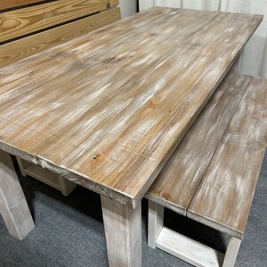 K&ouml;nnte beinhalten: Ein wei&szlig; get&uuml;nchter Holz-Esstisch mit einer passenden Bank. Der Tisch hat einen rustikalen, l&auml;ndlichen Stil und ist perfekt f&uuml;r einen zwanglosen Essbereich.