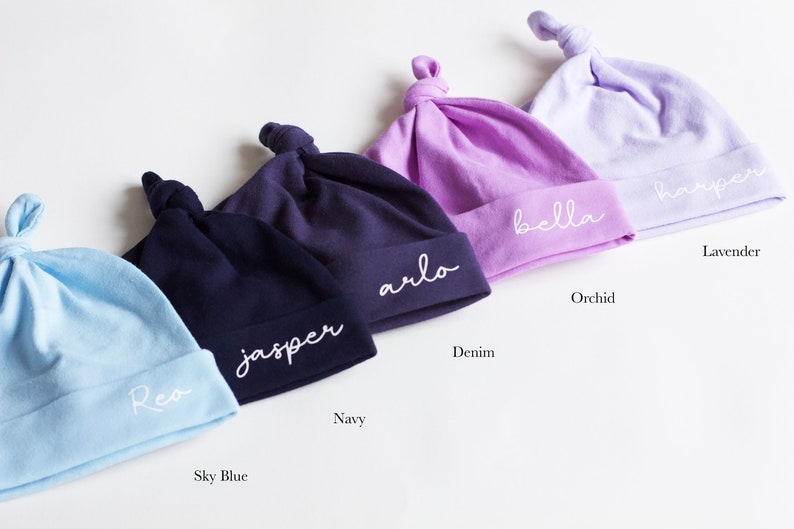 Peut inclure: Cinq bonnets pour b&eacute;b&eacute; personnalis&eacute;s dans diff&eacute;rentes couleurs&nbsp;: bleu ciel, marine, denim, orchid&eacute;e et lavande. Les bonnets sont en coton doux et ont un n&oelig;ud sur le dessus. Chaque bonnet est brod&eacute; d&rsquo;un nom diff&eacute;rent&nbsp;: Rea, Jasper, Arlo, Bella et Harper.