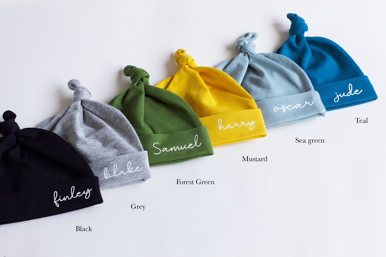 Peut inclure: Six bonnets pour b&eacute;b&eacute; personnalis&eacute;s dans diff&eacute;rentes couleurs, notamment noir, gris, vert for&ecirc;t, moutarde, vert d'eau et sarcelle. Chaque bonnet porte un nom diff&eacute;rent brod&eacute; : Finley, Blake, Samuel, Harry, Oscar et Jude.