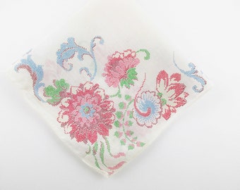 May include: A white cotton handkerchief with a floral pattern in shades of pink, blue, and green. The flowers are embroidered in a delicate stitch.