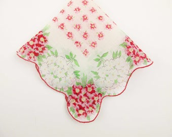 May include: A white handkerchief with a scalloped edge and a floral pattern in shades of red, green, and white.