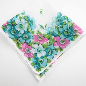 May include: White cotton handkerchief with a floral border design. The border features pink, blue, and green flowers.