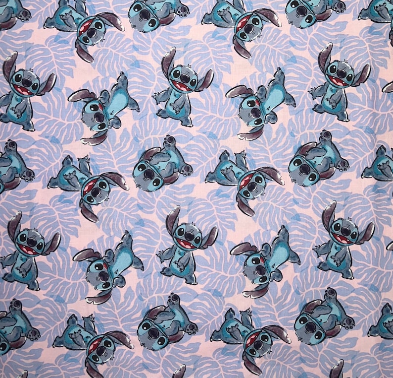 Pu&ograve; includere: Un tessuto bianco con un motivo ripetuto di personaggi Stitch blu dal film Disney Lilo & Stitch. I personaggi sono in varie pose e sono contornati di nero.