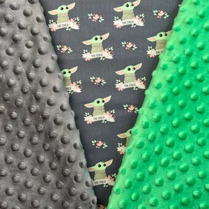 May include: Two pieces of fabric, one gray and one green, with a repeating pattern of a green alien character with the text "The Child" on a banner. Both fabrics have a textured, bumpy surface.