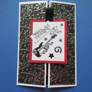 Verjaardagskaart voor een rockster: "you ROCK!" gitaar, sterren, edelstenen en swirl.  Muzieknoten op achtergrondpanelen.  Schuifopening. Kaart van 5 x 7 inch