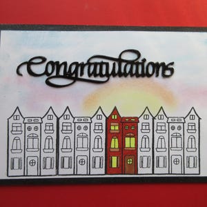 Nieuwe thuiskaart, 'Gefeliciteerd', op je nieuwe FLAT.  Flatgebouw, de zon komt op, het is een prachtige dag.