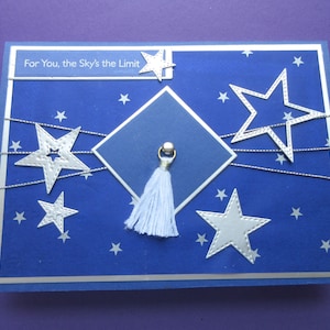 Biglietto di laurea, blu con stelle argentate. "Per te, il cielo è il limite". Cappello e nappa. Biglietto da 5 X 7 pollici, unico nel suo genere.