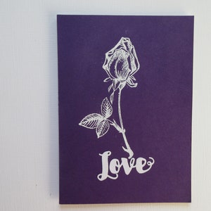 Tarjeta de San Valentín, hecha a mano, rosa blanca sobre fondo púrpura, elegante y simplista, sentimiento: "Amor"
