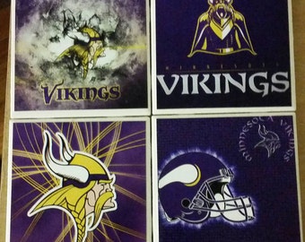 May include: Four square coasters featuring the Minnesota Vikings logo and imagery. Each coaster has a purple background with different designs, including the team name, a Viking head, and a helmet. The coasters are perfect for any Vikings fan.