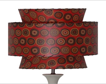 May include: A three-tiered lampshade with a red background and a pattern of concentric circles in shades of brown, orange, and white.