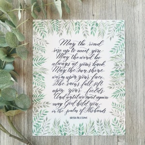 May include: A rectangular print with an Irish blessing in elegant calligraphy. The text is surrounded by a border of green watercolor leaves. The background is white, and the text is in black. The words "Irish Blessing" are at the bottom.