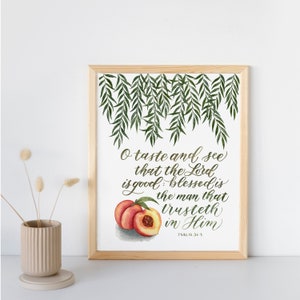 May include: A framed print with a watercolor illustration of peaches and a quote from Psalm 34:8, "O taste and see that the Lord is good: blessed is the man that trusteth in Him."