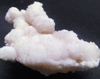 May include: A large, white, and pink cluster of crystals with a rough, textured surface.