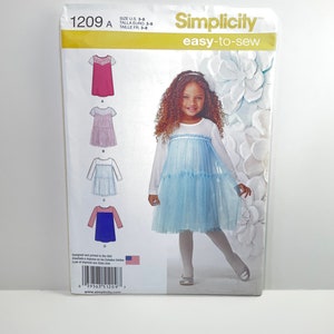 May include: Simplicity sewing pattern 1209A, easy-to-sew, for sizes US 3-8, Euro 3-8, and French 3-8. The pattern includes four different dress designs for girls. The front of the package shows a girl wearing a blue dress with a tulle skirt.
