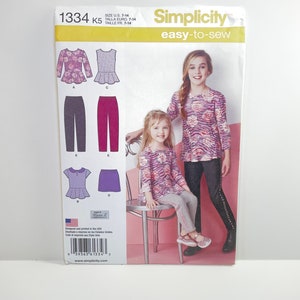 May include: Simplicity sewing pattern number 1334, size 7-14, easy-to-sew, for girls. The pattern includes instructions for making a long-sleeved top with a ruffle, a sleeveless top with a ruffle, leggings, and a skirt.