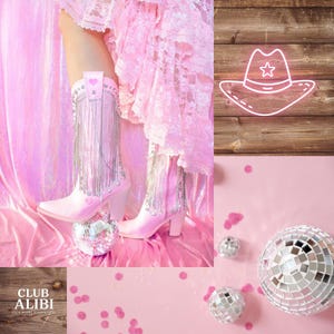 May include: Pink knee-high cowboy boots with silver fringe and heart details. The boots are on a pink surface with disco balls and confetti. A neon cowboy hat sign is in the background.