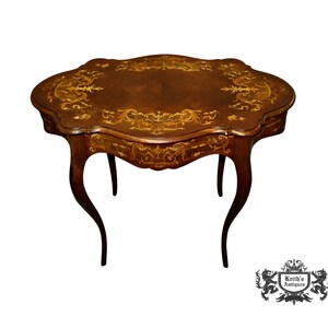 May include: A brown wooden table with intricate marquetry inlay. The table has a scalloped top and cabriole legs.