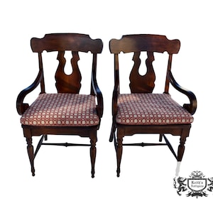 May include: A set of three ceramic mugs with a speckled, cream-colored glaze. Each mug features a different hand-painted design: a blue and green leaf, a yellow flower, and a red berry. The mugs have a simple, modern design.