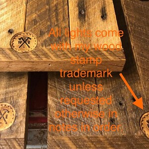 May include: Close-up of a wooden surface with a brown stamp that says "W & E" with two crossed hammers. The text "All lights come with my wood stamp trademark unless requested otherwise in notes in order." is visible in the image.